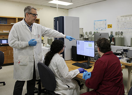 Pictured: Dr. Michael LaMontagne demonstrates how the MALDI-TOF spectrometer is used