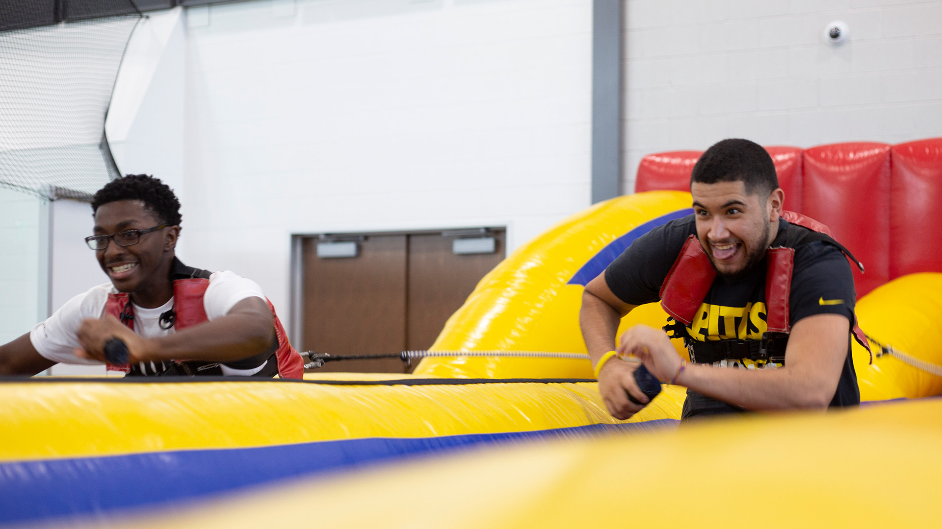 Two students pulling ropes in an inflatable game